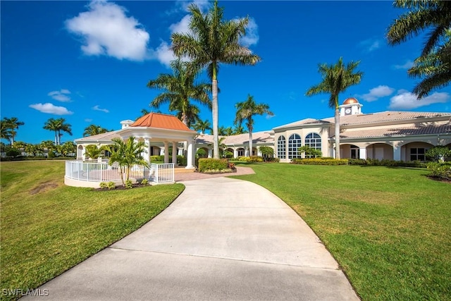 view of community with a yard, concrete driveway, and a gazebo