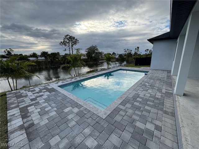 view of swimming pool with a water view and a patio