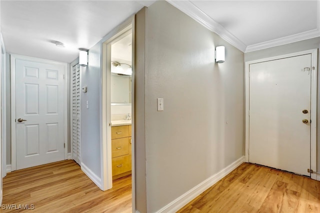 hallway featuring light hardwood / wood-style floors and crown molding