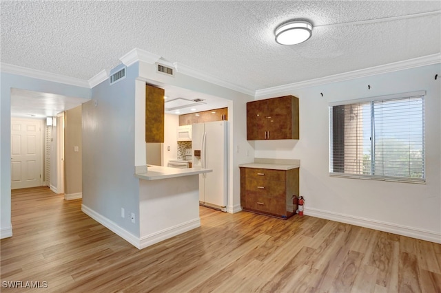 kitchen featuring kitchen peninsula, crown molding, light wood-type flooring, a textured ceiling, and white fridge with ice dispenser