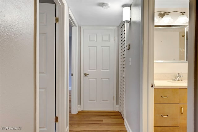 hallway featuring sink and light hardwood / wood-style floors