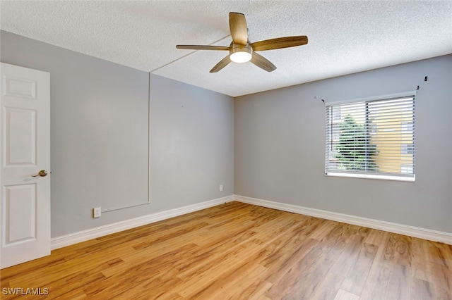 unfurnished room with ceiling fan, light wood-type flooring, and a textured ceiling