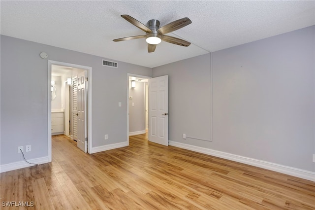 unfurnished bedroom featuring ceiling fan, light hardwood / wood-style flooring, a textured ceiling, and ensuite bath