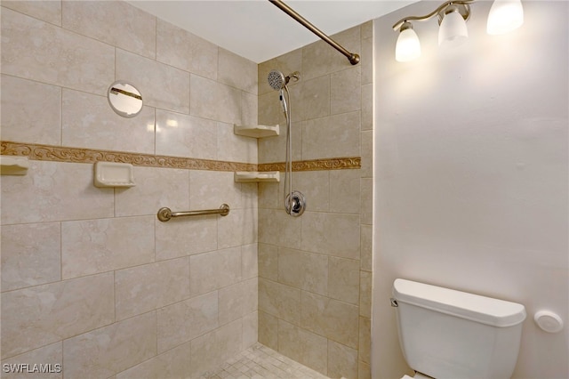 bathroom featuring a tile shower and toilet