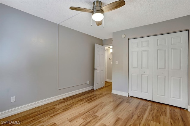 unfurnished bedroom featuring light wood-type flooring, ceiling fan, a closet, and a textured ceiling