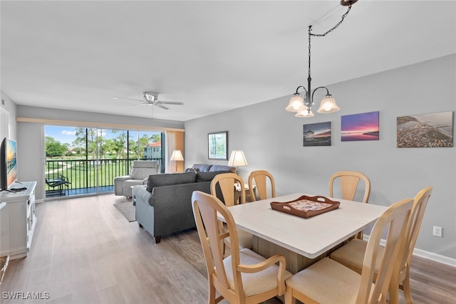 dining space featuring light hardwood / wood-style floors and ceiling fan with notable chandelier