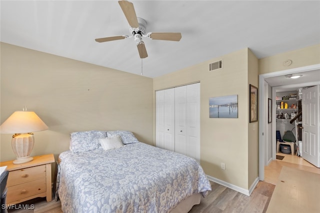 bedroom featuring ceiling fan, light wood-type flooring, and a closet