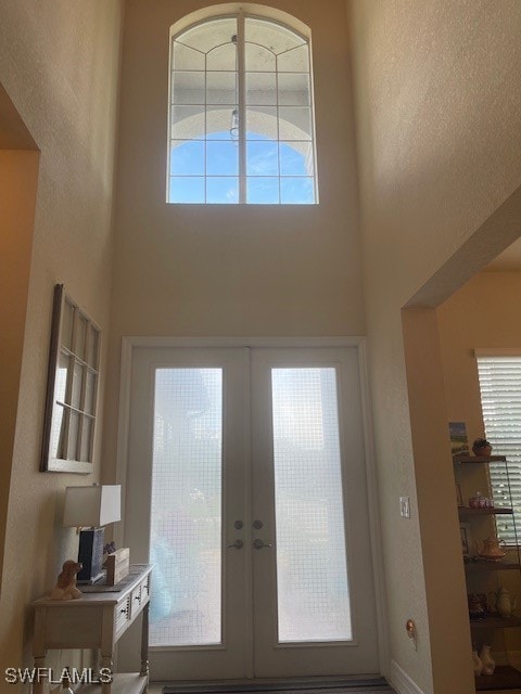 doorway to outside with french doors and a high ceiling