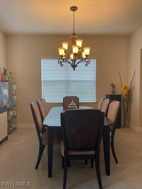 tiled dining room with a notable chandelier