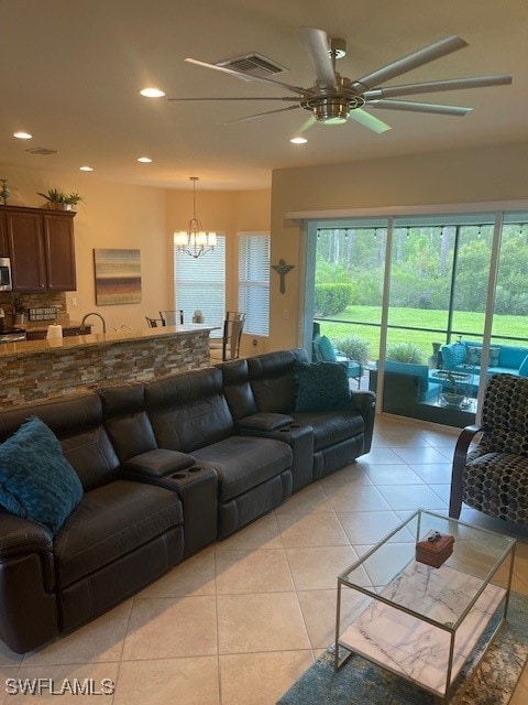 living room with ceiling fan with notable chandelier and light tile patterned floors