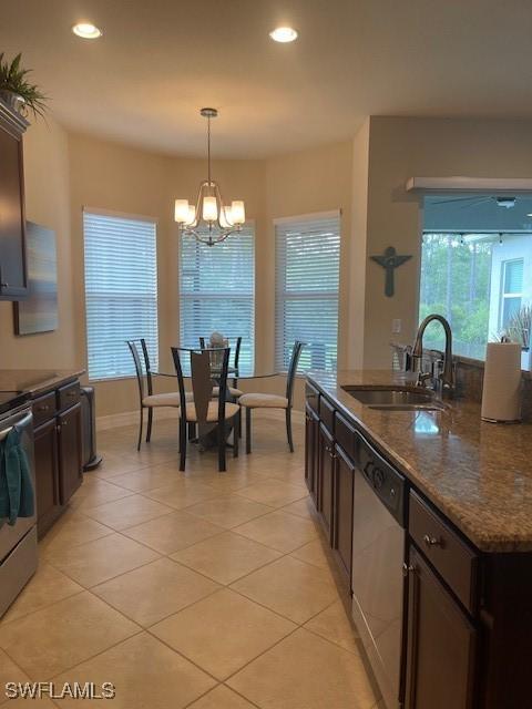 kitchen with stainless steel appliances, dark brown cabinets, and a sink