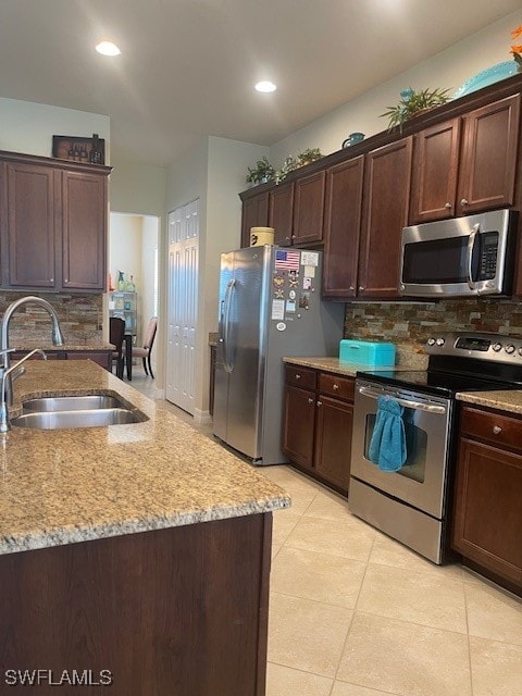 kitchen featuring sink, tasteful backsplash, appliances with stainless steel finishes, and light tile patterned floors