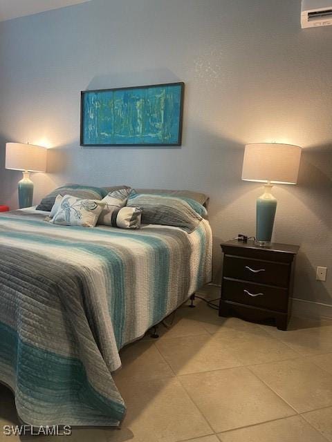 bedroom featuring light tile patterned floors and an AC wall unit