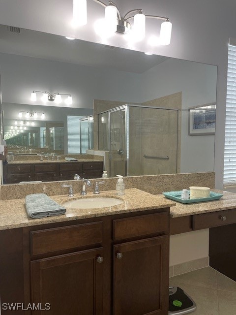 bathroom featuring tile patterned flooring, an enclosed shower, and vanity