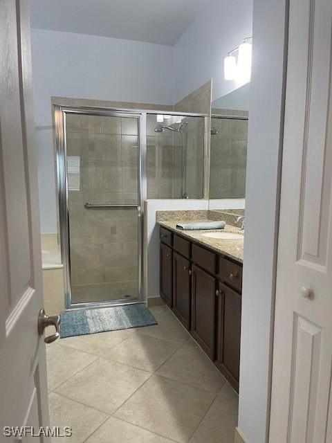 full bath with tile patterned flooring, a sink, a shower stall, and double vanity