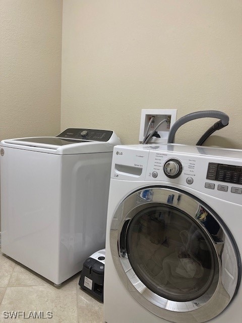 washroom featuring washer and dryer and light tile patterned floors