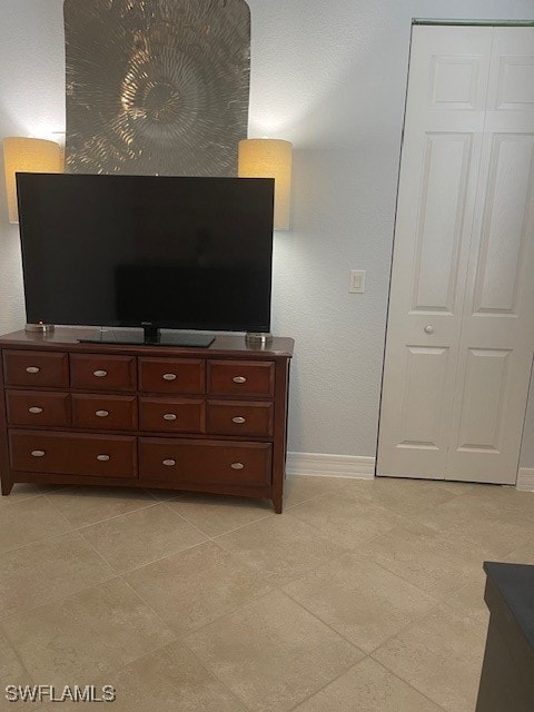 bedroom with light tile patterned flooring and a closet