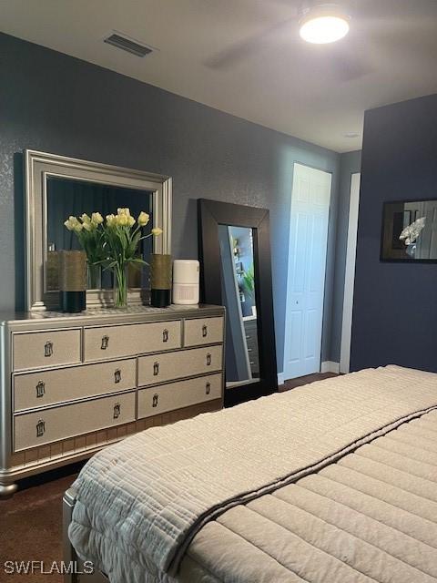 bedroom with dark carpet and visible vents