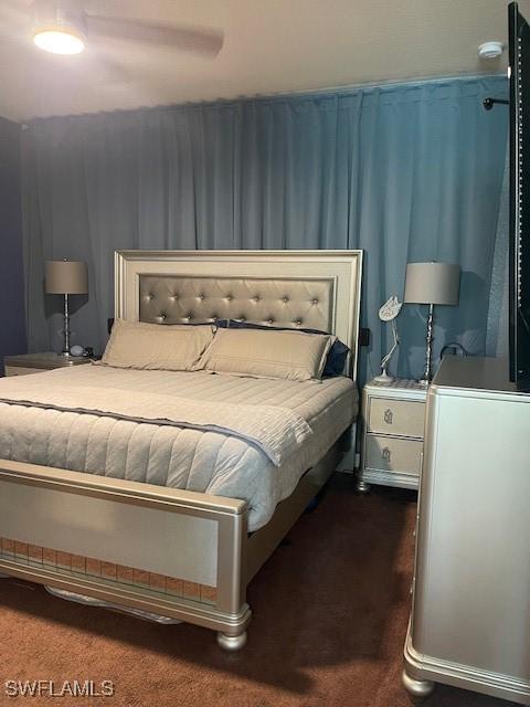 bedroom with dark colored carpet and a ceiling fan