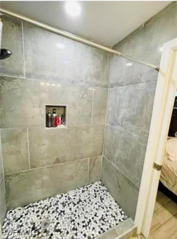 bathroom featuring tile patterned flooring and tiled shower