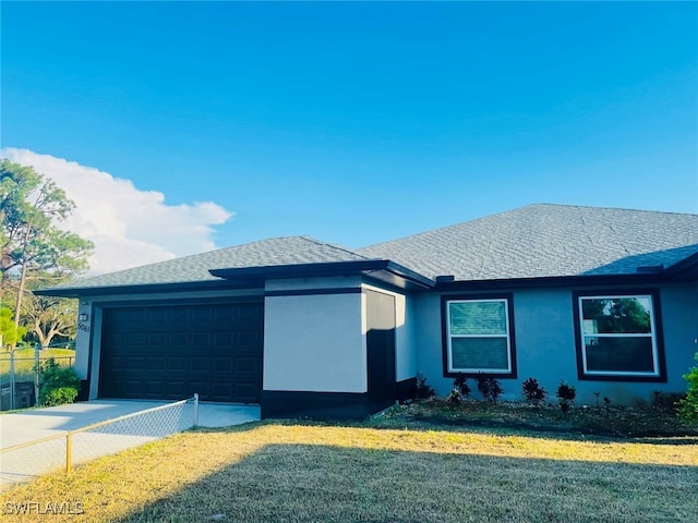 view of front of property featuring a front yard and a garage