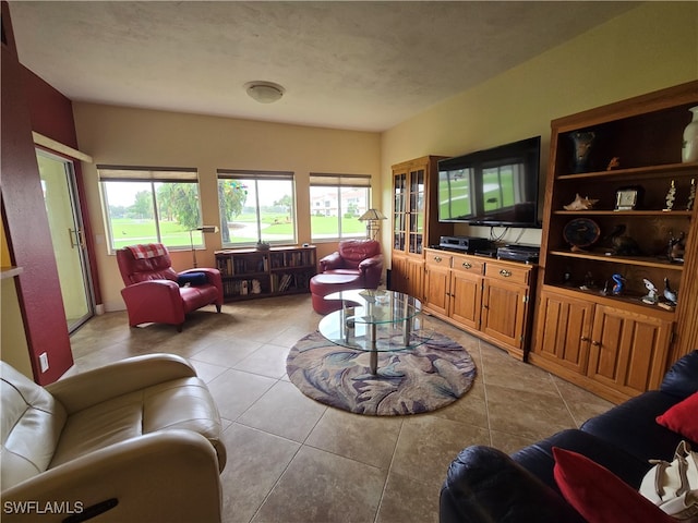 living room with a textured ceiling and light tile patterned floors