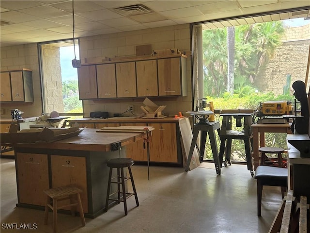 13331 Medinah Cir W Unit 1, Fort Myers, FL 33907 - kitchen featuring a breakfast bar, visible vents, concrete flooring, butcher block counters, and a center island