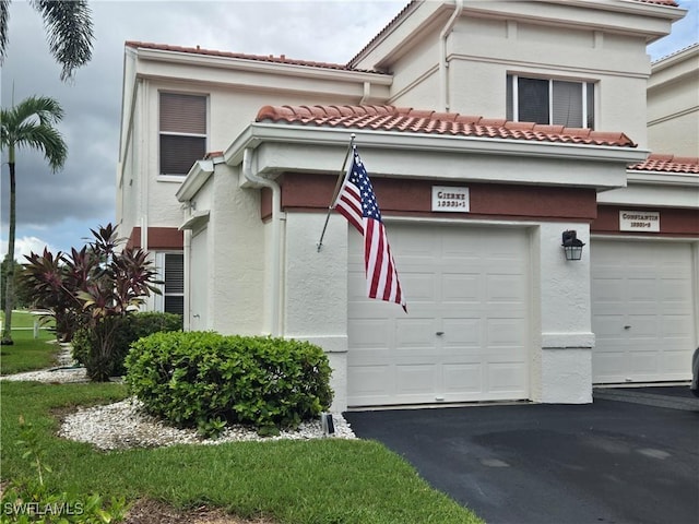 13331 Medinah Cir W Unit 1, Fort Myers, FL 33907 - view of side of home with stucco siding, a tile roof, and driveway