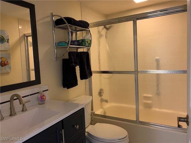 full bathroom with bath / shower combo with glass door, vanity, and toilet