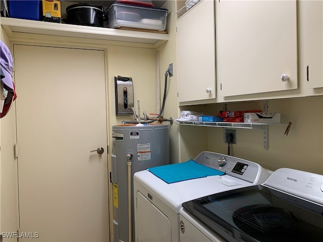 laundry room with cabinets, water heater, and washer and dryer