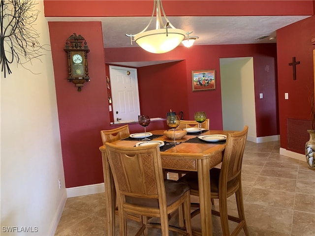 tiled dining area with a textured ceiling