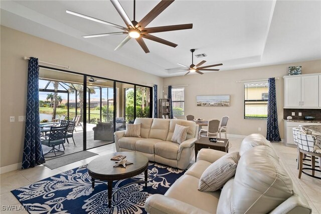 tiled living room with a wealth of natural light and ceiling fan