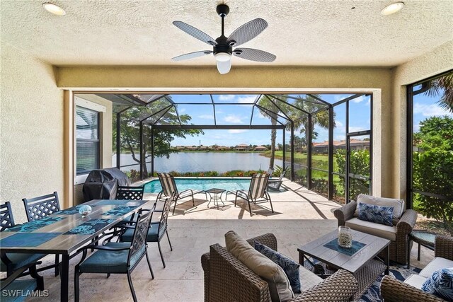 view of patio / terrace with a grill, an outdoor hangout area, a water view, glass enclosure, and ceiling fan