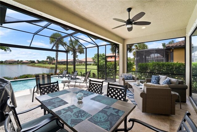 sunroom / solarium featuring a water view and ceiling fan