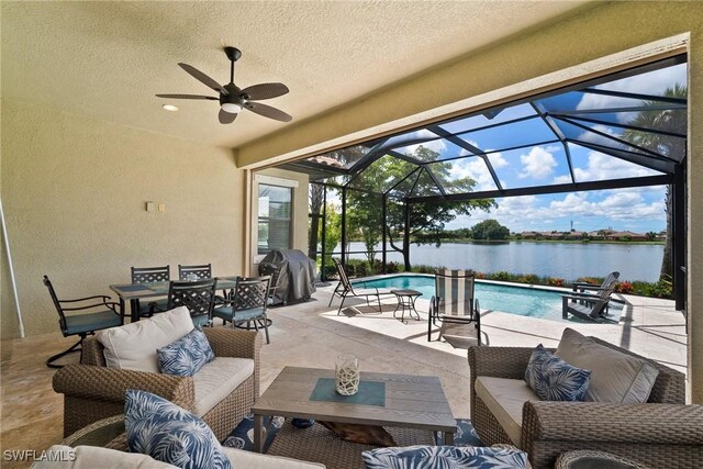 view of patio featuring area for grilling, a water view, an outdoor living space, a lanai, and ceiling fan