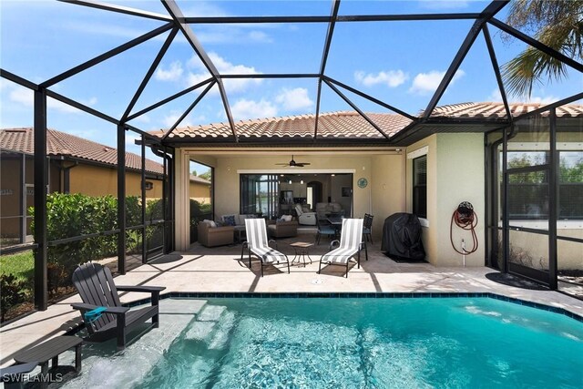 view of swimming pool featuring a patio, glass enclosure, ceiling fan, and an outdoor living space