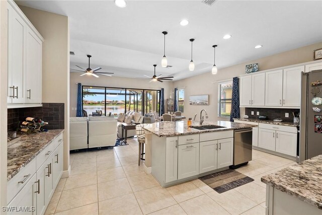 kitchen with ceiling fan, an island with sink, sink, stainless steel dishwasher, and decorative light fixtures