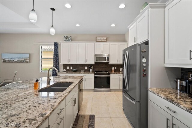 kitchen with light tile patterned floors, sink, white cabinetry, appliances with stainless steel finishes, and light stone countertops