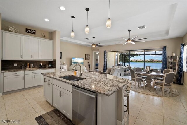 kitchen featuring dishwasher, sink, an island with sink, white cabinets, and ceiling fan