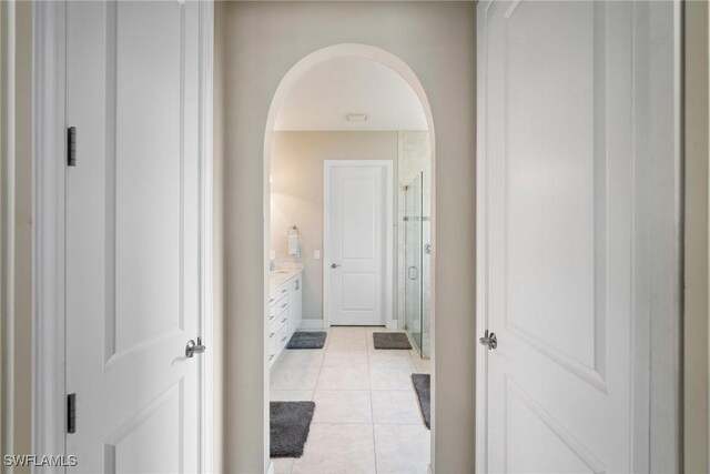 bathroom with tile patterned flooring, a shower with door, and vanity