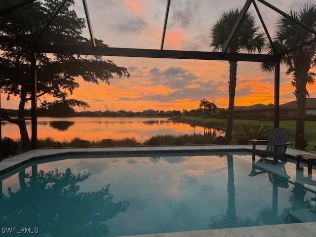 pool at dusk featuring a water view