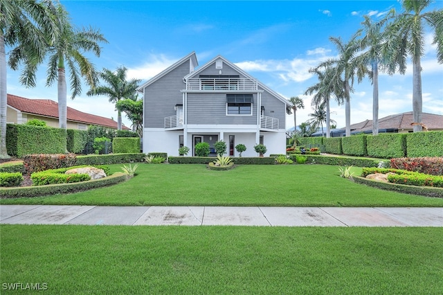 view of front facade with a balcony and a front lawn