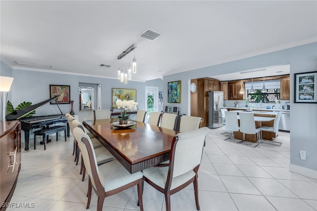 tiled dining area with a chandelier and crown molding