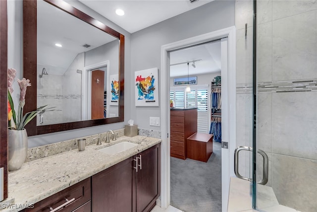 bathroom with walk in shower, vaulted ceiling, and vanity