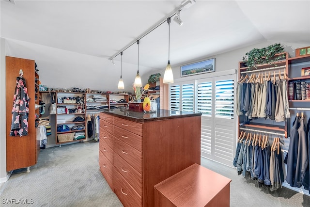 walk in closet with lofted ceiling and light carpet