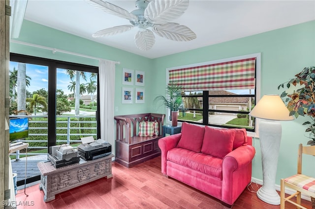 living area featuring a wealth of natural light, hardwood / wood-style floors, and ceiling fan