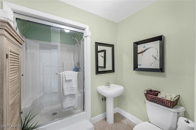 bathroom featuring tile patterned flooring, toilet, and walk in shower