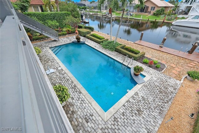 view of swimming pool with a water view, a dock, and a patio