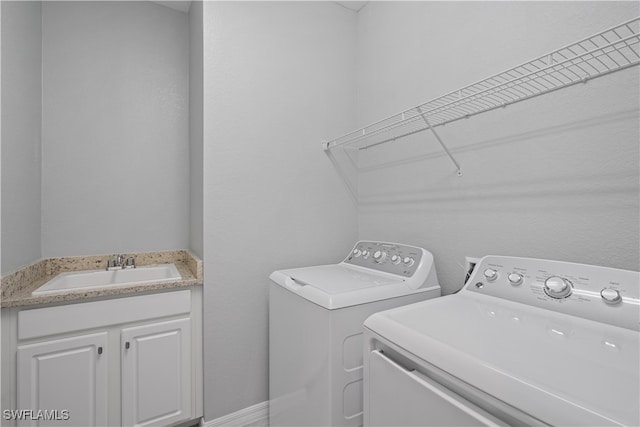 clothes washing area featuring separate washer and dryer and sink