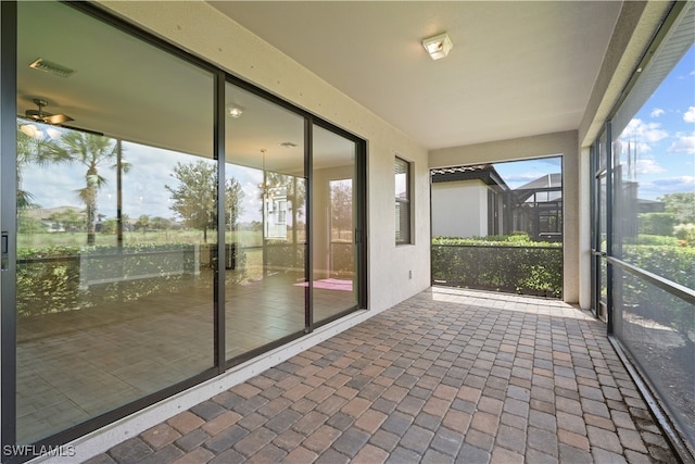 unfurnished sunroom with a water view and ceiling fan